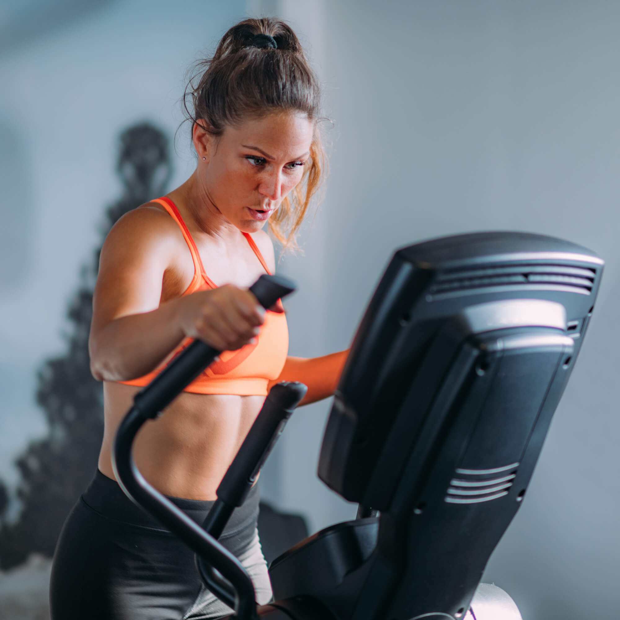 woman-exercising-on-elliptical-cross-trainer-2023-11-27-05-07-01-utc